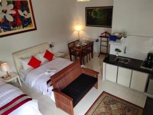 a bedroom with a bed and a kitchen with a table at Kurau Inn Farmstay in Kuala Kurau