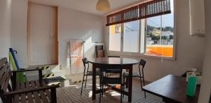 a dining room with a table and chairs and a window at Chalet Ludovina in Estoril