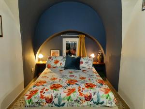 - une chambre avec un lit et une couette à fleurs dans l'établissement Casa Famoso, à Catane