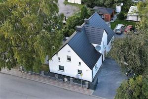 uma grande casa branca com um telhado preto em Jagodowy Dwór em Jastarnia