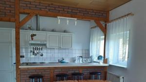 a kitchen with white cabinets and bar stools at Vera in Hitzacker