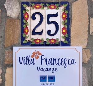 a sign with the number on a wall at Affittacamere Villa Francesca in Pula