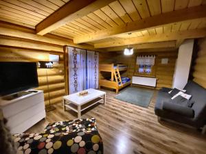 a living room with a couch and a bed at Anielska Chata in Istebna