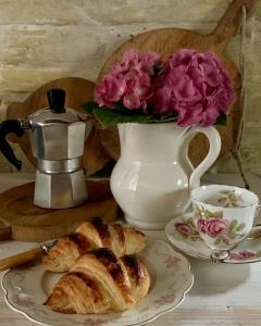 einen Tisch mit einem Teller Brot und eine Vase mit Blumen in der Unterkunft Piccola Corte Antica in Corticelle Pieve