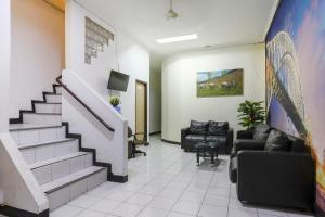 a lobby with a staircase and a waiting room at Good Sleep Balikpapan Mitra RedDoorz in Balikpapan