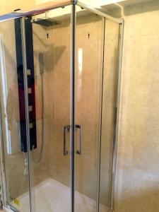 una ducha con puerta de cristal en un baño en Perla Sirmione, en Sirmione 38 fotos más