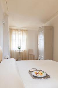 - un lit blanc avec une assiette de nourriture dans l'établissement B&B Fior Di Farine, à La Morra