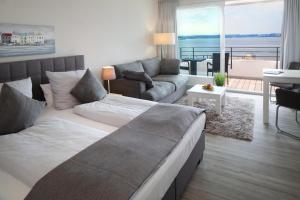 a bedroom with a large bed and a living room at Intermar Hotel & Apartments in Glücksburg