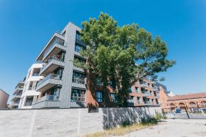 een hoog gebouw met een boom ervoor bij Garden - Quiet Apartment in the City Center in Krakau