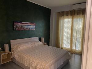 ein Schlafzimmer mit einem Bett und einer grünen Wand in der Unterkunft Nidama house in Neapel
