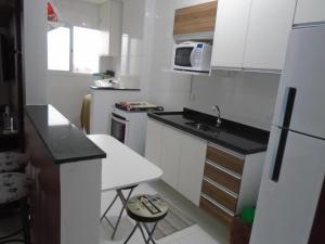 a small kitchen with a sink and a refrigerator at Apartamento em Mongaguá, Frente ao Mar in Mongaguá