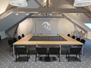 une salle de conférence avec une grande table et des chaises dans l'établissement Logis Hotel Restaurant de l'Abbaye, à Ferrières