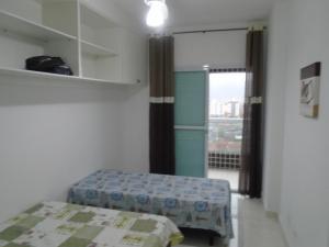 a small room with a bed and a window at Apartamento em Mongaguá, Frente ao Mar in Mongaguá +24 photos