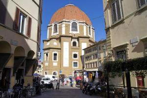 un edificio alto con una torre de reloj en una calle en Melarancio Apartments, en Florencia