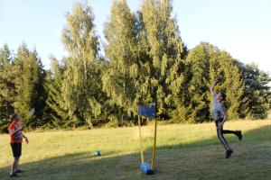 dos chicas jugando con un frisbee en un campo en Villa Mamry en Węgorzewo