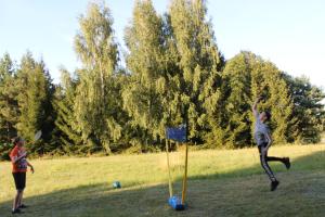 dos chicas jugando con un frisbee en un campo en Villa Mamry, en Węgorzewo