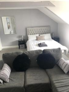 uma sala de estar com um sofá em frente a uma cama em Bay View Apartment em Newbiggin-by-the-Sea