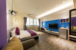 a hotel room with a bed and a tv at Tainan Pickup Light in Anping