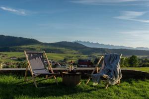 two chairs sitting in the grass next to a table at Loft&Hill in Grywałd