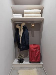 un armario con un abrigo y una maleta roja en Residenza Conca Verde B&B Il monolocale, en Rogolo