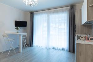 cocina con ventana, mesa y escritorio en Residenza Conca Verde B&B Il monolocale, en Rogolo 3 fotos más