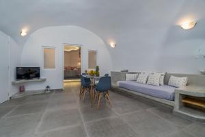 a living room with a couch and a table at Cally Cave House in Fira