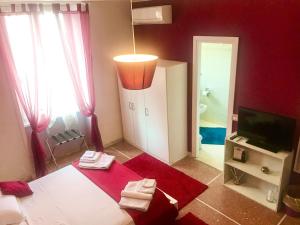 a red room with a bed and a television and a bathroom at A Casa Di Giallo B&B in Rome