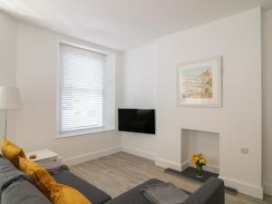 uma sala de estar com um sofá e uma televisão em Samphire em Teignmouth