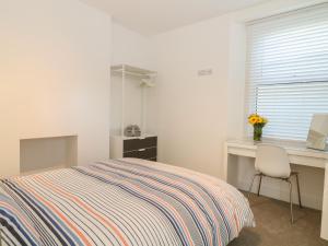 - une chambre avec un lit, un bureau et une fenêtre dans l'établissement Samphire, à Teignmouth