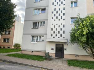 a white building with a door and a bench at Apartament MATEO in Malbork