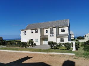 a large white house with a gray roof at BEAUTIFUL COTTAGE FANTASTIC BEACH in Oyster Bay