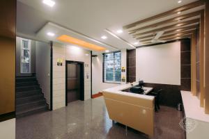 a lobby with a reception desk and stairs in a building at Hotel Rahul Palace Belgaum in Belgaum
