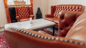 two leather chairs and a table in a living room at Avantgarde Hotel in Hattingen