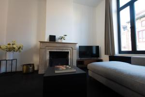 a living room with a fireplace and a couch at Villa Beau Séjour in Bruges