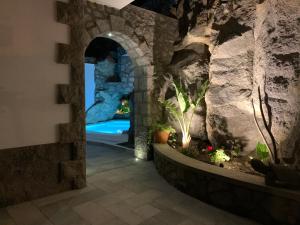 um quarto com uma parede de pedra e um aquário em Rock House Villa em Ischia