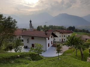 een wit gebouw met een klokkentoren in de verte bij Villetta Casale in Comano Terme