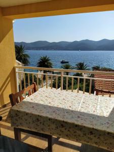 una mesa en un balcón con vistas al agua en Apartman Luka, en Viganj