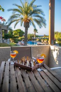 シティアにあるSitia Oceanidesのチェスボード、木製テーブルの上に置かれたグラスワイン2杯
