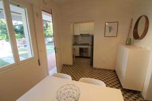 una cucina con tavolo, sedie e frigorifero di Villetta Sonia a Lignano Sabbiadoro