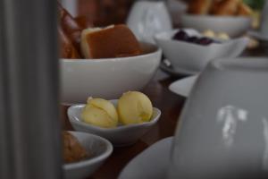 una mesa con tazones blancos de comida. en Altavista Casahotel - Asociado Casa Andina, en Moyobamba