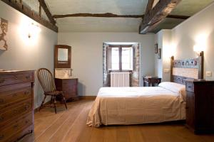 a bedroom with a bed and a dresser and a window at Casa Berdeal in Mañón