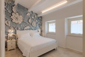 a bedroom with a bed with a floral accent wall at Marinelli Apartments - La Madonnina in Osimo