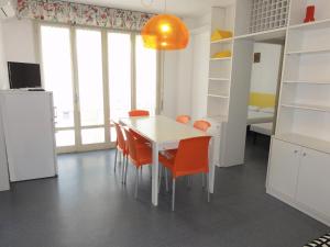 ビビオーネにあるAdriatico - Appartamentiのキッチン(白いテーブル、オレンジの椅子付)