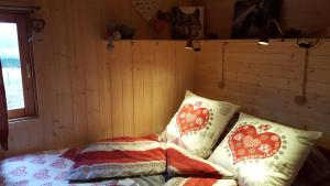 a bedroom with a bed with pillows on it at Ma Roulotte sous les Chênes "la passionnée" in Raon-aux-Bois