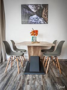 a dining room table with four chairs and a vase on it at Ferienwohnung Naturnah in Goslar