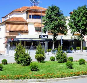 a building with a garden in front of a building at Vila A Hotel in Korçë