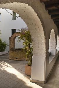 einen Steinbogen mit einer Topfpflanze auf einer Terrasse in der Unterkunft Hotel Convento Aracena & SPA in Aracena