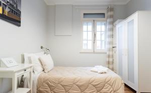a small bedroom with a bed and a window at Lisboa Central Hostel in Lisbon
