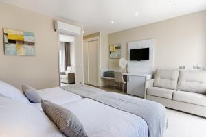 a white bedroom with a bed and a couch at Sanom Beach Resort Only Adults in Playa del Ingles