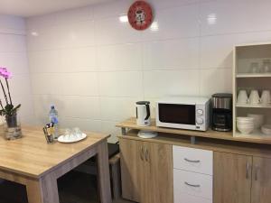 a kitchen with a table and a microwave on a counter at Pension Luna in Hildesheim